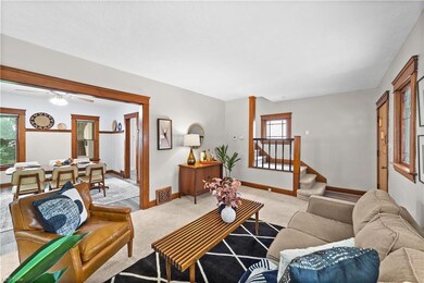 Carpeted living room with ceiling fan