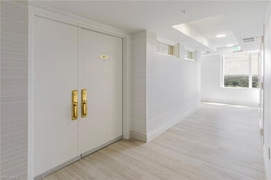 Corridor featuring a raised ceiling, light wood-style floors, and baseboards