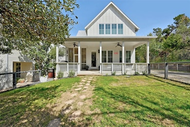 View of front of house with a ceiling fan, board 