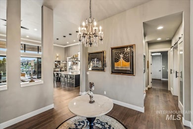 Hall with a barn door, wood finished floors, recessed lighting, and a chandelier