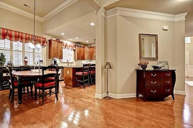 Dining area with wood finished floors and crown molding