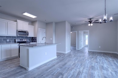 Kitchen with white cabinets, an island with sink, 