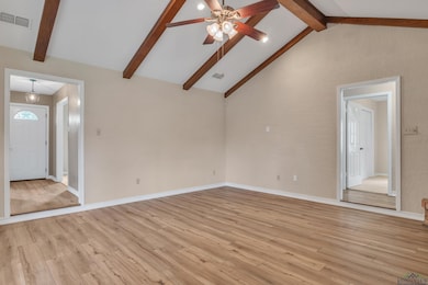 Unfurnished living room with lofted ceiling with beams, ceiling fan, visible vents, and light wood-type flooring