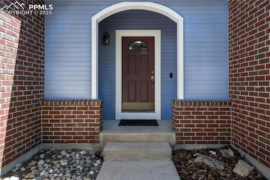 Doorway to property featuring brick siding