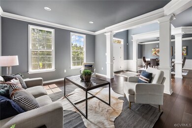 Hardwood floored living room with crown molding an