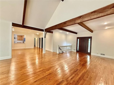 Unfurnished living room featuring light wood finished floors and baseboards