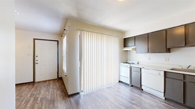 Kitchen with light wood-type flooring, white appli