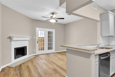 Kitchen featuring light stone countertops, light w