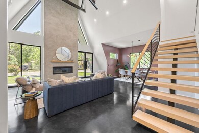 Living area with a towering ceiling, a fireplace,