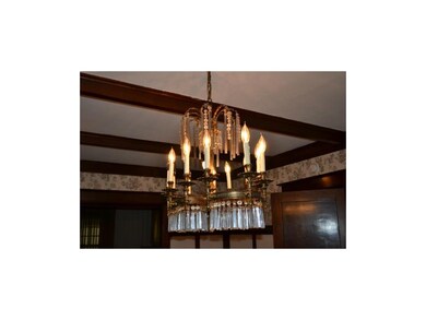 Dining room crystal chandelier & wood beams.