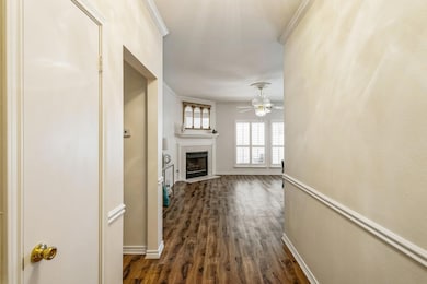 Hallway with dark wood-style floors, baseboards, a