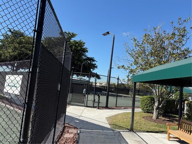 View of tennis court featuring a gate