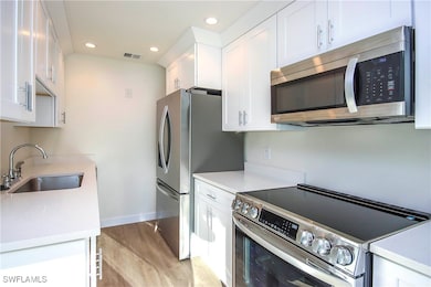 Kitchen featuring light wood-type flooring, white
