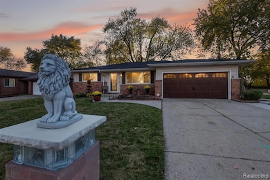 View of front of property with concrete driveway, a front yard, an attached garage, and brick siding