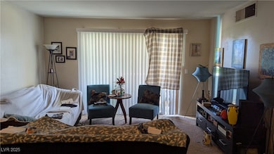 Carpeted living area with a textured wall