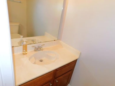 Half bathroom featuring vanity and toilet