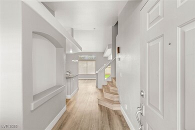Foyer featuring baseboards, stairs, and light wood