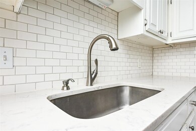 Kitchen view of a sink, decorative backsplash, wh