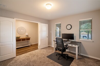Office area featuring light carpet and baseboards