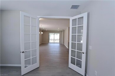 Hall featuring french doors, baseboards, recessed 
