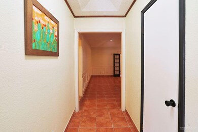 Hallway with ornamental molding and light tile patterned floors