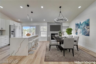 Dining room featuring vaulted ceiling, recessed li