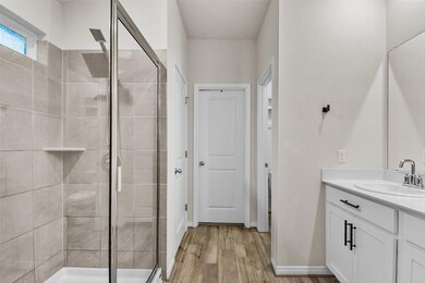 Bathroom with a shower stall, vanity, wood finish