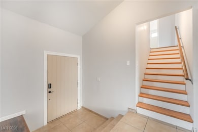 Stairs featuring tile patterned flooring and vaulted ceiling