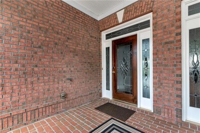 View of exterior entry with brick siding and a porch