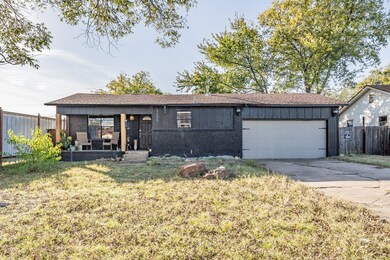 Single story home featuring brick siding, a garage, driveway, roof with shingles, and board and batten siding