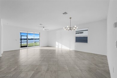 Spare room featuring a water view, a ceiling fan, a chandelier, and light tile patterned flooring