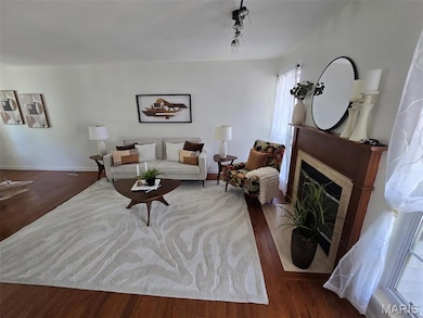 Living room with wood finished floors and a fireplace with flush hearth