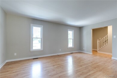 The living room has laminate wood flooring and ent