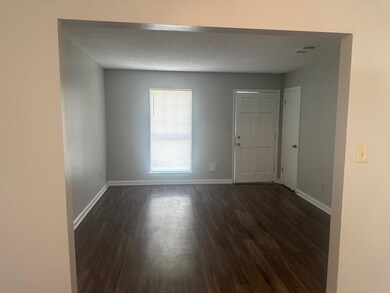 Unfurnished room featuring dark wood-type flooring and a textured ceiling