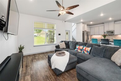 Living room featuring ceiling fan, dark wood fini