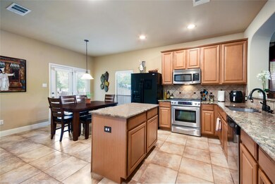 Kitchen featuring light stone countertops, stainl