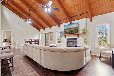 Living area featuring a stone fireplace, a wealth 