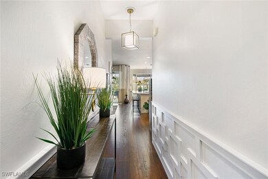 Corridor featuring wainscoting and dark wood-style