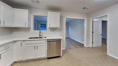 Kitchen featuring stainless steel dishwasher, whit