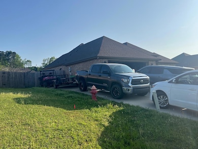 View of home's exterior with a garage, a yard, fen