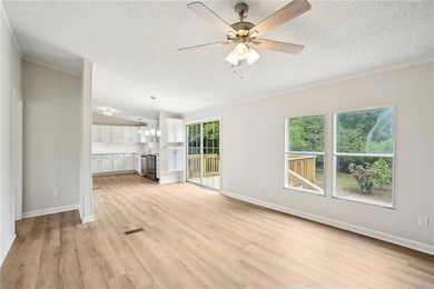 Unfurnished living room featuring a textured ceili