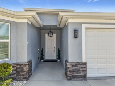 Entrance to property with an attached garage, ston