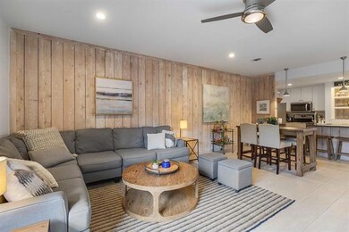 Living room featuring wood walls, a ceiling fan, 