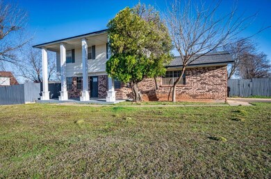 Rear view of house with a lawn, brick siding, and 