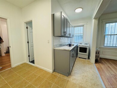 Kitchen featuring light countertops, gray cabinets, white electric stove, and tasteful backsplash