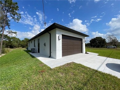 Garage featuring cooling unit and driveway
