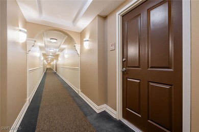 Hall featuring a tray ceiling and dark carpet