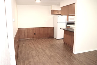Kitchen featuring white appliances, dark countert