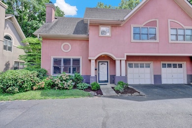 Multi unit property featuring stucco siding, a chimney, driveway, an attached garage, and a shingled roof