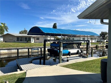 Dock area with a lawn, boat lift, and a water view